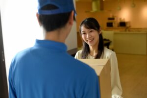 郵便物を自宅で受け取る女性